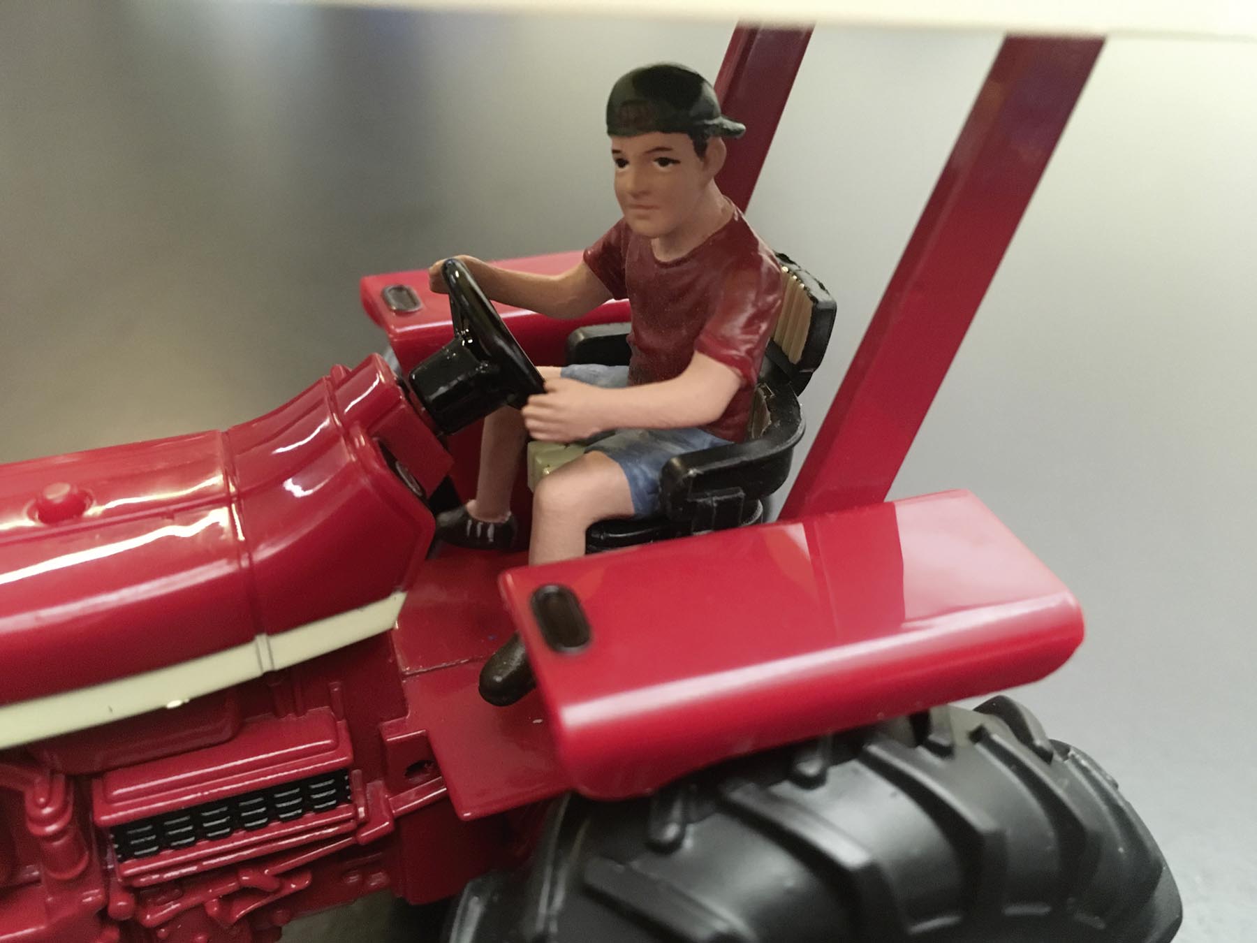 Teenager Jeff fährt Traktor Modell von AT Collections 1:32